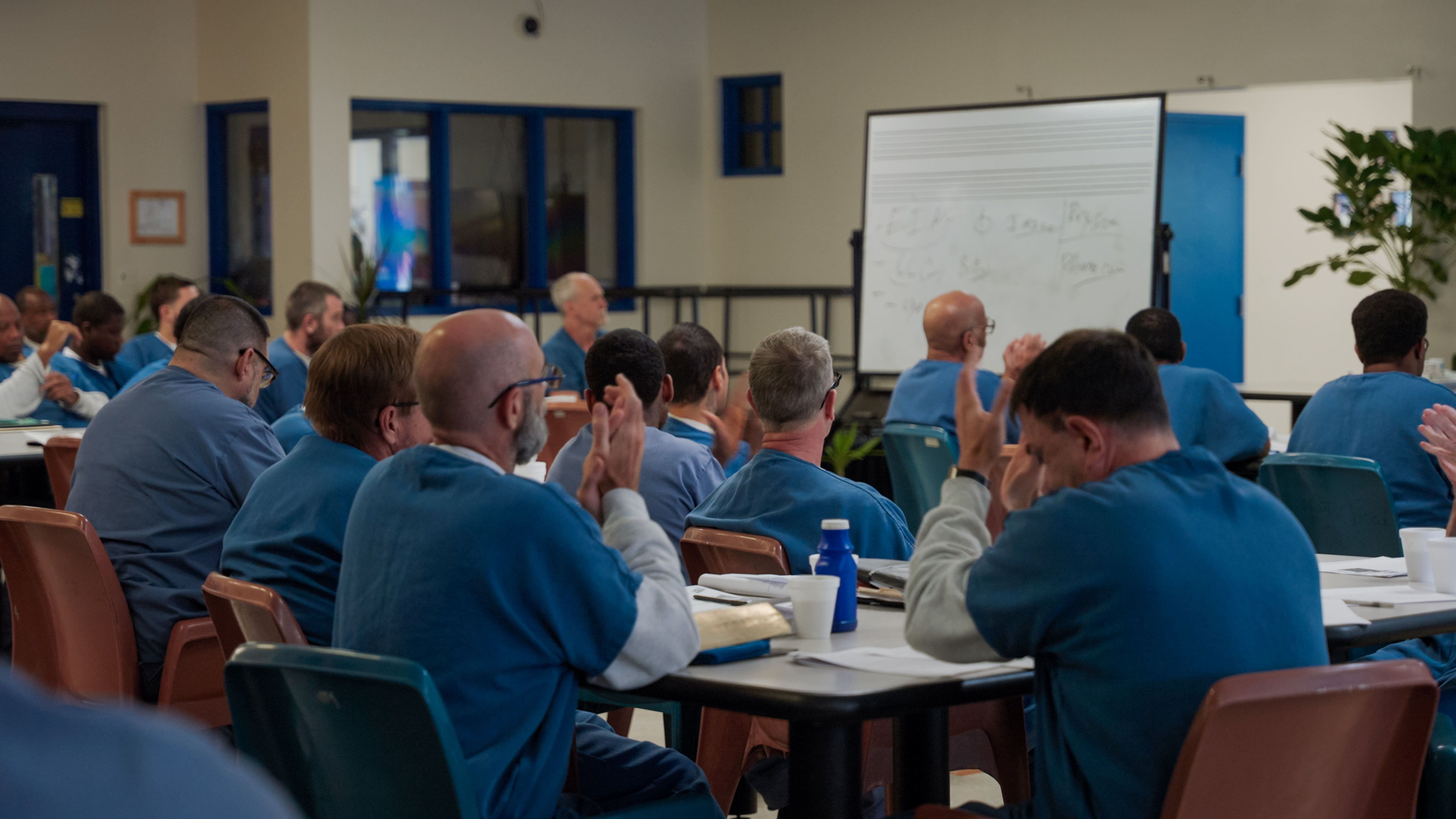 Men in blue sitting during Bounce Forward curriculum session